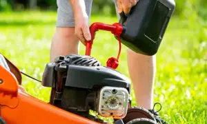 Mężczyzna nalewa paliwo do kosiarki. Zastanawiasz się, jakie paliwo do kosiarki będzie najlepsze?