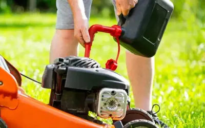 Mężczyzna nalewa paliwo do kosiarki. Zastanawiasz się, jakie paliwo do kosiarki będzie najlepsze?