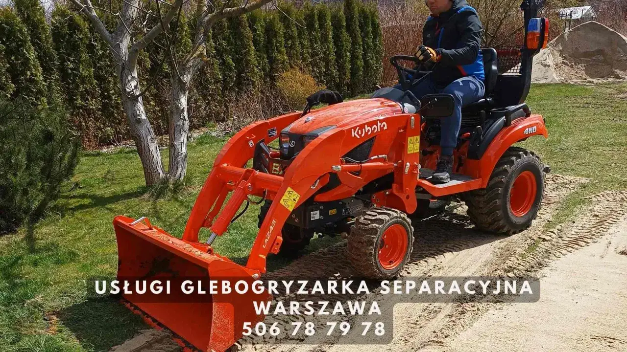 Pomarańczowa glebogryzarka Kubota z operatorem na tle ogrodu. Usługi glebogryzarką separacyjną w Warszawie. Zapytaj, ile kosztuje godzina pracy glebogryzarki.